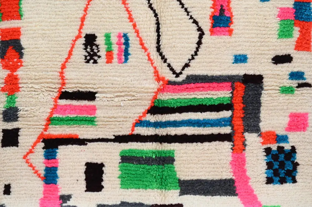 Vibrant geometric-patterned DecorBites™ handmade Moroccan Azilal rug with natural wool in bold pink green blue colors