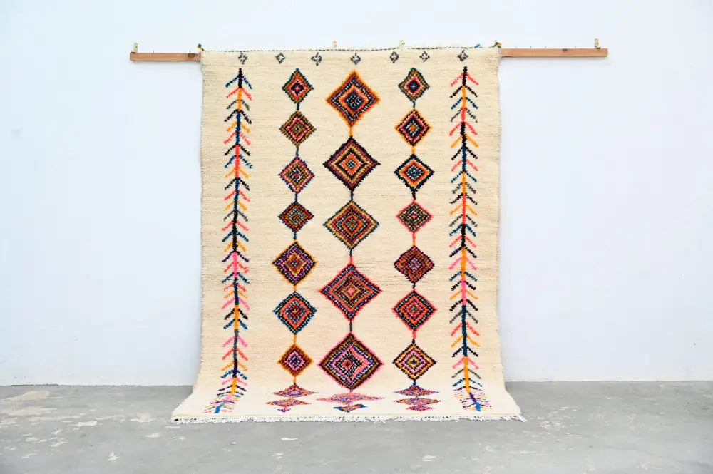 Beige woven decorbites handmade moroccan azilal rug 236x155cm with geometric diamond and arrow patterns in orange red pink and black