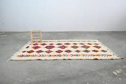 Cream-colored decorbites™ handmade moroccan azilal rug 236x155cm with intricate red purple and multicolored geometric patterns