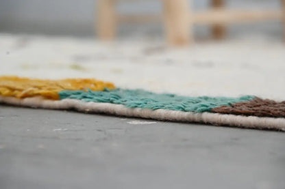 Colorful moroccan handmade azilal rug with woven edge featuring yellow teal and brown yarn bands 237x146 cm
