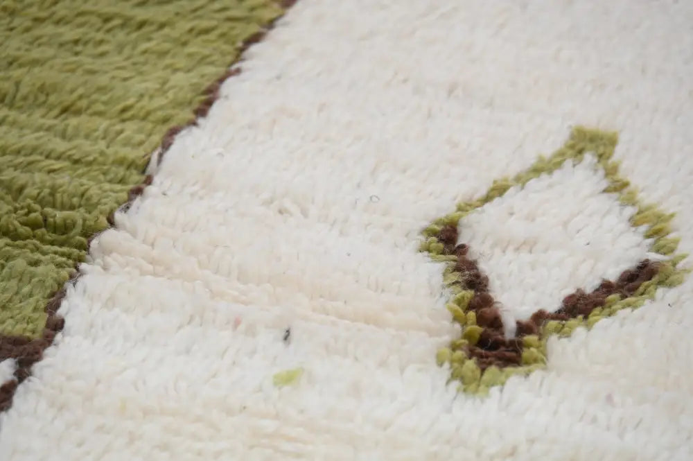 A cream-colored moroccan handmade azilal rug with textured surface and olive green embroidered leaf design 237x146 cm