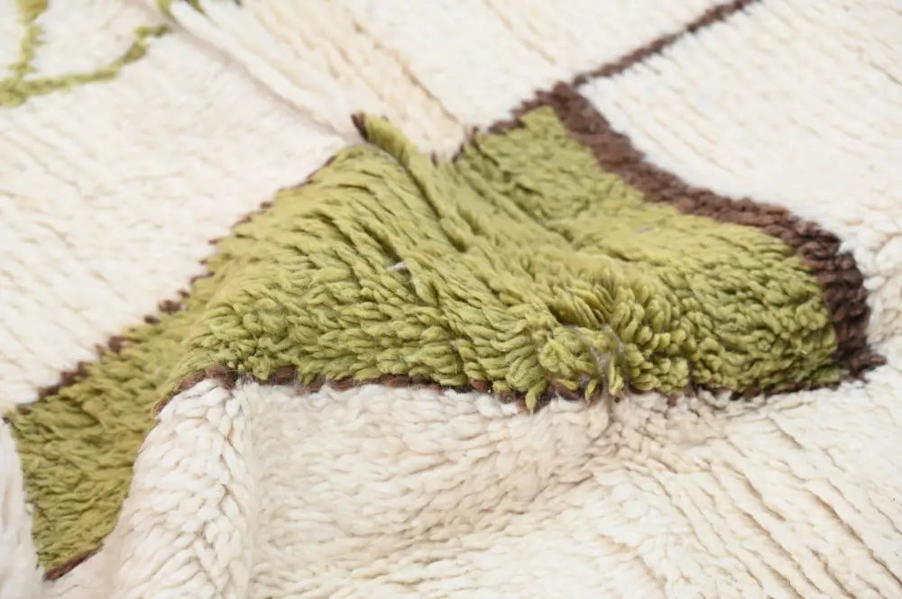 A plush olive-green and cream moroccan handmade azilal rug with a textured shaggy surface by DecorBites™