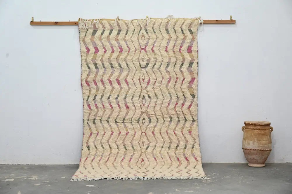 Beige woven handmade moroccan azilal rug with zigzag pattern in muted pink and olive green with fringed edges