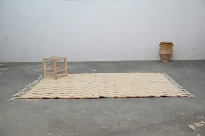 Cream-colored handmade moroccan azilal rug with textured wavy pattern and fringed edges 238x144cm decorbites