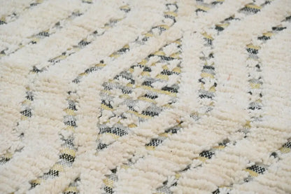 Cream-colored handmade moroccan azilal rug 240x155cm with textured woven pattern featuring black and beige geometric designs