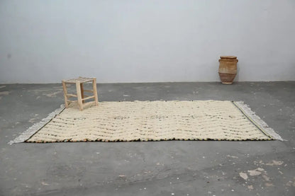 Cream-colored handmade moroccan azilal rug 240x155cm with textured chevron pattern and fringed edges by decorbites