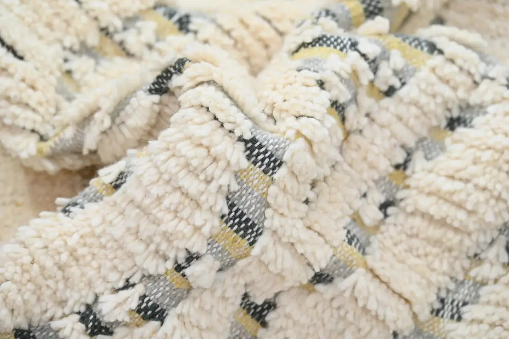 Cream-colored plush throw blanket with woven black and mustard yellow stripes featured in handmade moroccan azilal rug 240x155cm