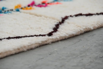 White woolen decorbites™ handmade moroccan azilal rug with fluffy texture and bold dark burgundy geometric borders