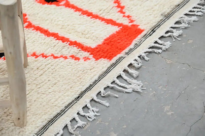 Cream-colored handmade moroccan azilal rug with bold orange geometric patterns and fringed edges 245x141cm decorbites