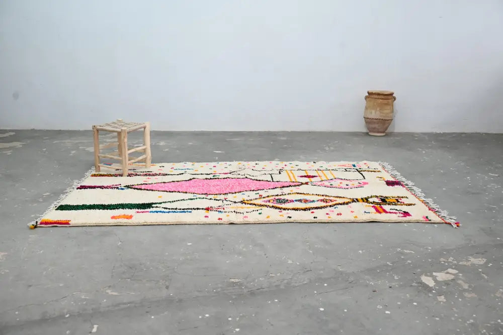 Beige moroccan azilal rug with vibrant pink green yellow and orange geometric patterns handmade by decorbites