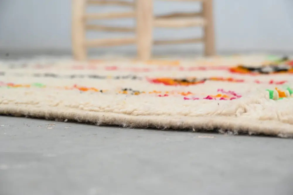 Cream-colored handmade moroccan azilal rug with vibrant multicolored geometric patterns and fringed edge 246x146 cm