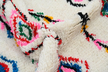 A decorbites™ handmade moroccan azilal rug in off-white natural wool with vibrant geometric patterns in multiple colors