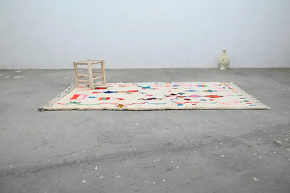 A cream-colored handmade moroccan azilal rug with colorful geometric and abstract patterns by DecorBites™