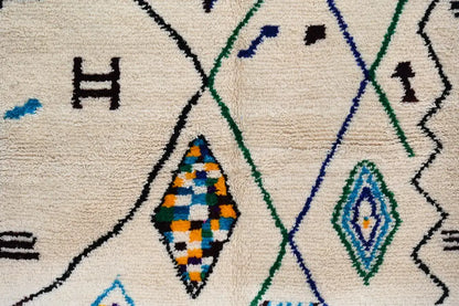 Cream-colored handmade moroccan azilal rug with intricate black green blue and orange geometric patterns 250x141 cm