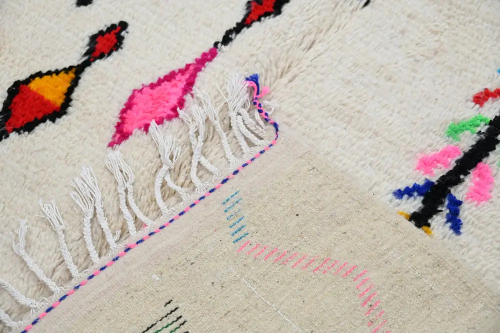 Decorbites™ handmade cream-colored moroccan azilal rug with vibrant geometric patterns and fringed edge 250x145 cm