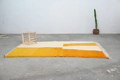 A vibrant yellow and cream moroccan handmade azilal rug with textured hand-knotted design and fringed edges by decorbites