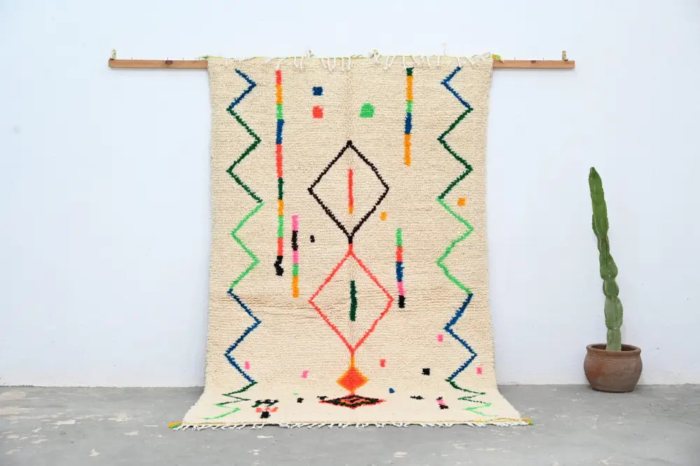 Beige moroccan azilal rug with colorful geometric patterns in red green blue orange made of natural wool 253x150 cm