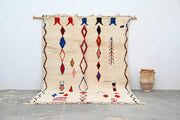Beige handmade moroccan azilal rug by decorbites with bold red blue and black geometric patterns 285x220 cm