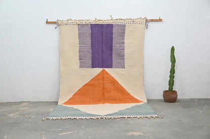 DecorBites™ handmade moroccan azilal rug with beige purple and orange geometric design in natural wool hanging on wooden rod