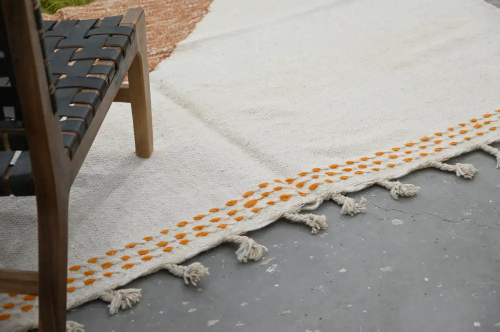 Cream-colored handmade moroccan azilal rug with orange dot pattern and fringed edges 291x200cm