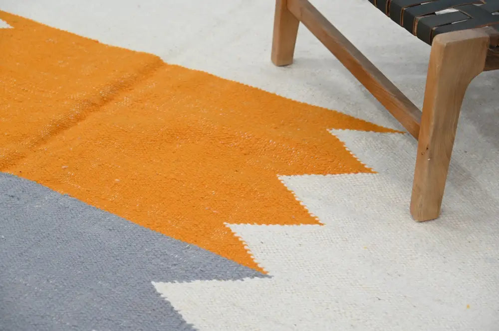A vibrant orange and gray moroccan handmade traditional azilal rug with a textured woven surface by decorbites
