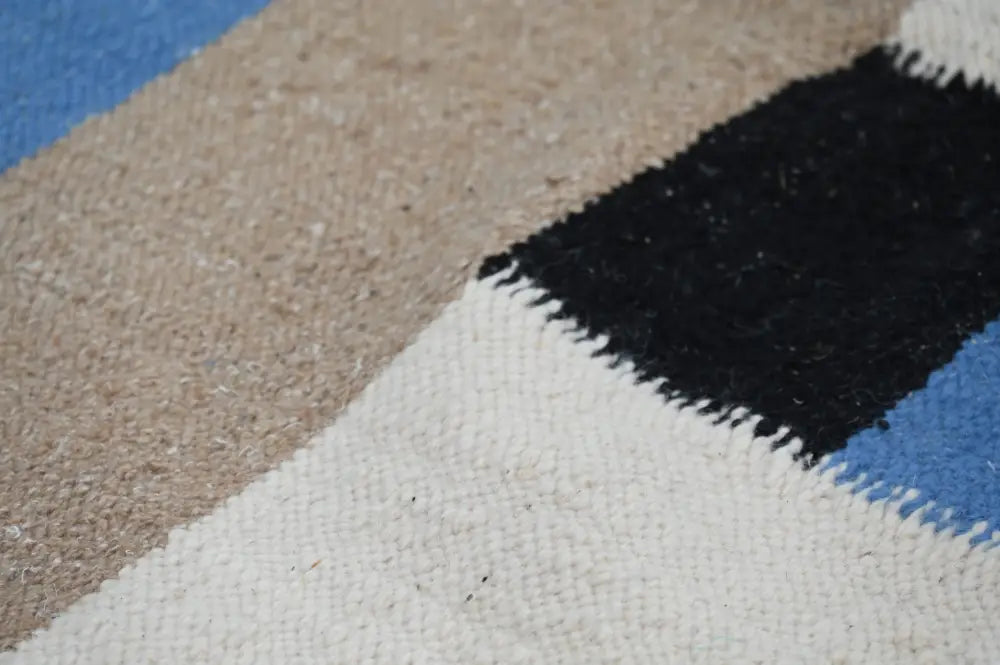 A decorbites™ handmade traditional azilal rug featuring bold black blue beige and white geometric patterns showcasing moroccan craftsmanship