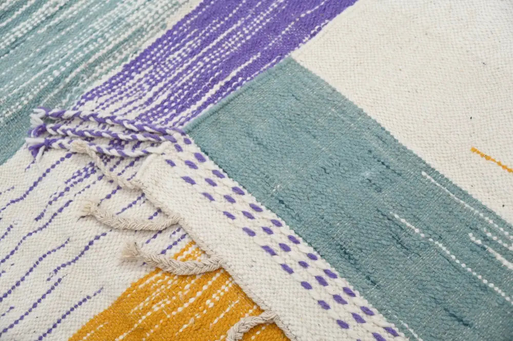 A handmade moroccan azilal rug 302x197cm with a geometric pattern in teal purple and cream tones