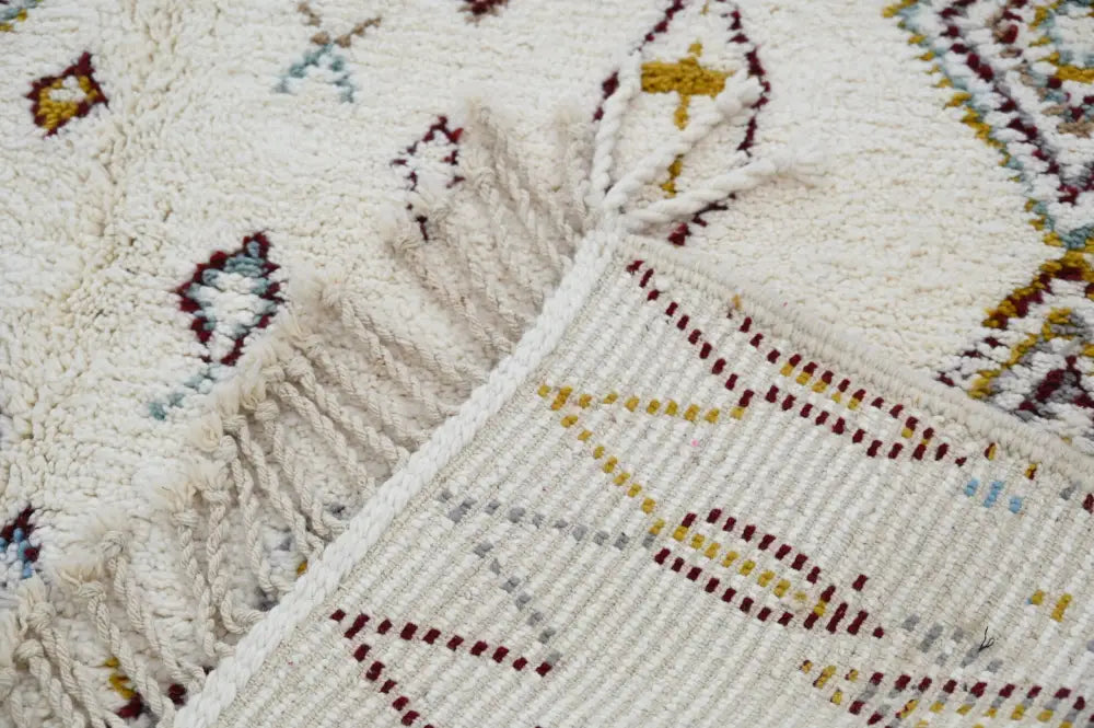 Cream-colored handmade moroccan azilal rug with intricate maroon gold and blue geometric patterns 305x206cm decorbites