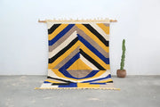 Vibrant handmade moroccan azilal rug with bold yellow blue black and beige stripes in a geometric abstract pattern