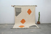 Beige woven handmade moroccan azilal rug with bold black and orange geometric patterns and fringed edges 308x200 cm