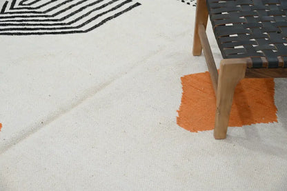 Cream-colored handmade moroccan azilal rug with bold black geometric patterns and vibrant orange accent patch 308x200 cm
