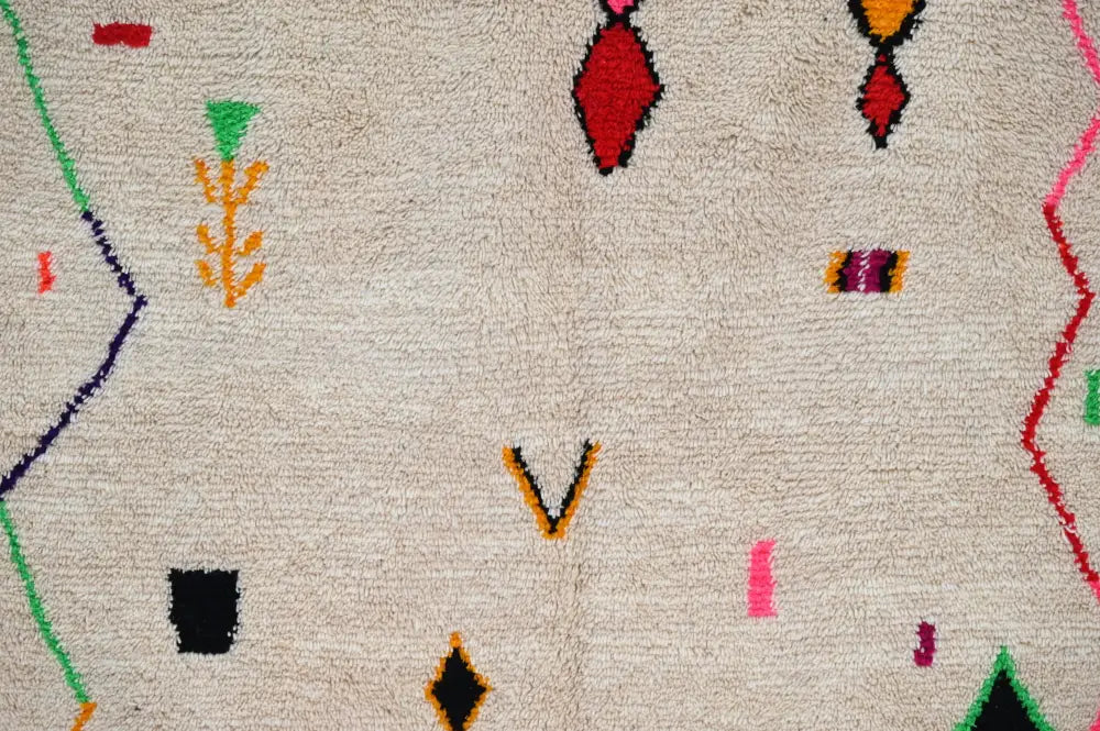 Beige handmade moroccan azilal rug with vibrant red green orange black and pink geometric patterns 309x195cm