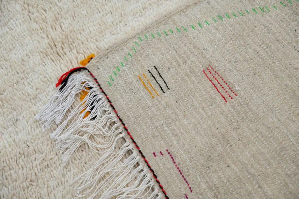 Beige woven decorbites™ handmade moroccan azilal rug with fringed edges and colorful geometric embroidery 309x195cm