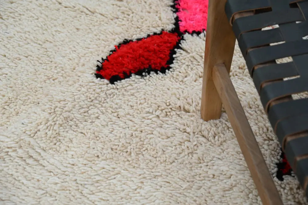 Cream-colored shaggy handmade moroccan azilal rug with bold red and black abstract geometric patterns 309x195cm