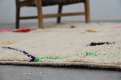 Cream-colored plush wool azilal rug with vibrant purple green and black embroidery handmade moroccan azilal rug 309x195cm