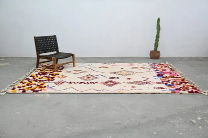 Beige handmade moroccan azilal rug with colorful geometric and floral patterns and fringed edges 309x207cm