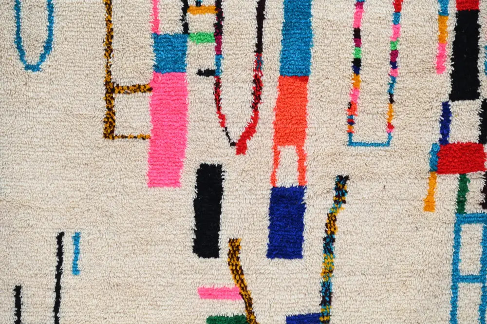 Decorbites™ handmade moroccan azilal rug with vibrant geometric patterns and multicolored vertical stripes on cream base