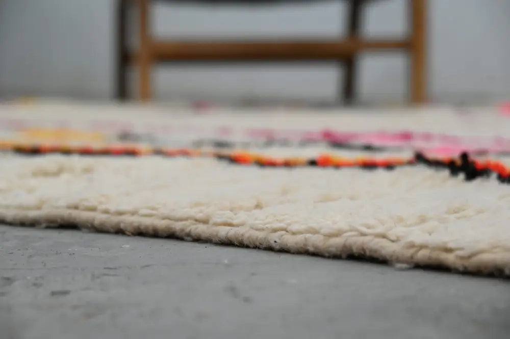 Cream-colored handmade moroccan azilal rug with vibrant pink orange and black horizontal wool stripes 315x194 cm
