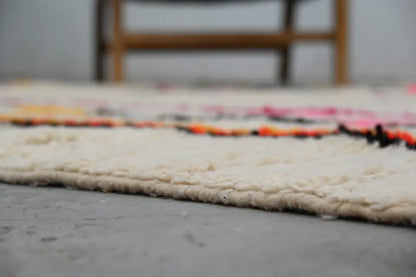 Cream-colored handmade moroccan azilal rug with vibrant pink orange and black horizontal wool stripes 315x194 cm