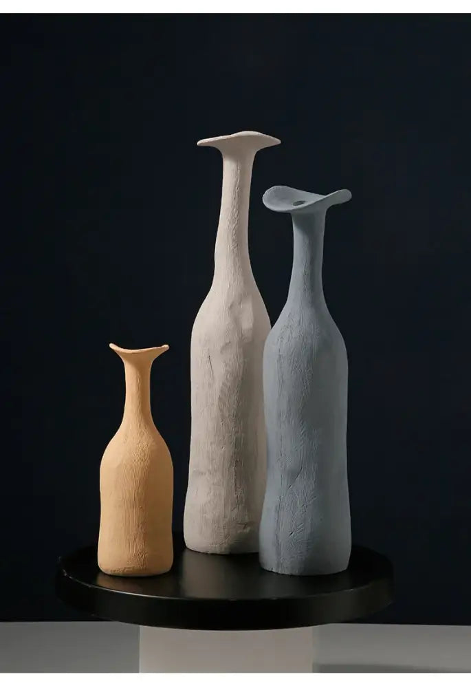 Three minimalist ceramic flower vases in beige off-white and light blue with textured surfaces for luxury home decor