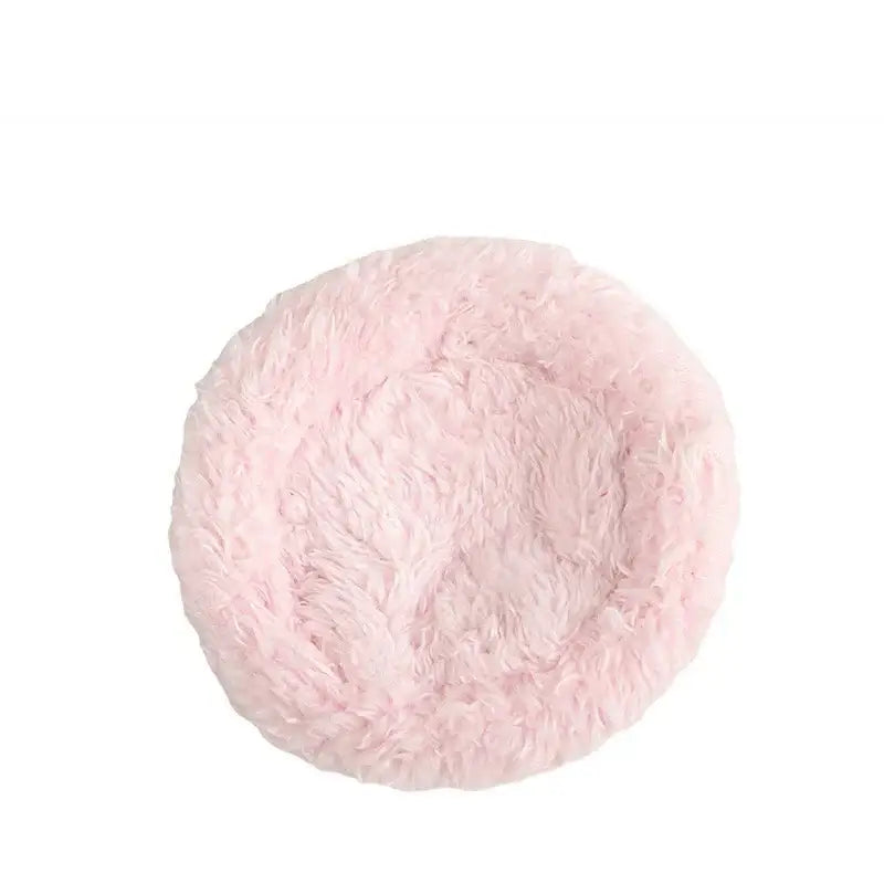 Pink fluffy pet bed with soft plush texture placed inside a handwoven grass bird cage hut for small birds