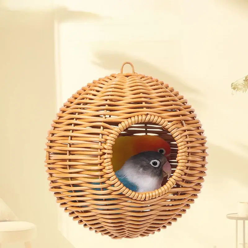 DecorBites™ handwoven grass bird cage with heart-shaped opening housing two colorful parrots in a wicker nest