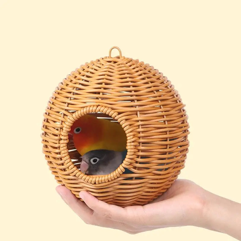 Decorbites handwoven grass bird cage hut in natural color with round entrance holding two small birds inside