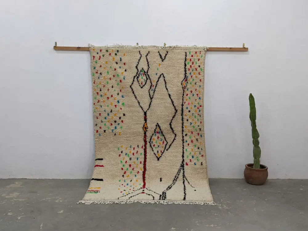 Cream-colored handwoven moroccan azilal rug with intricate black red geometric patterns and multicolored dots 234x147 cm