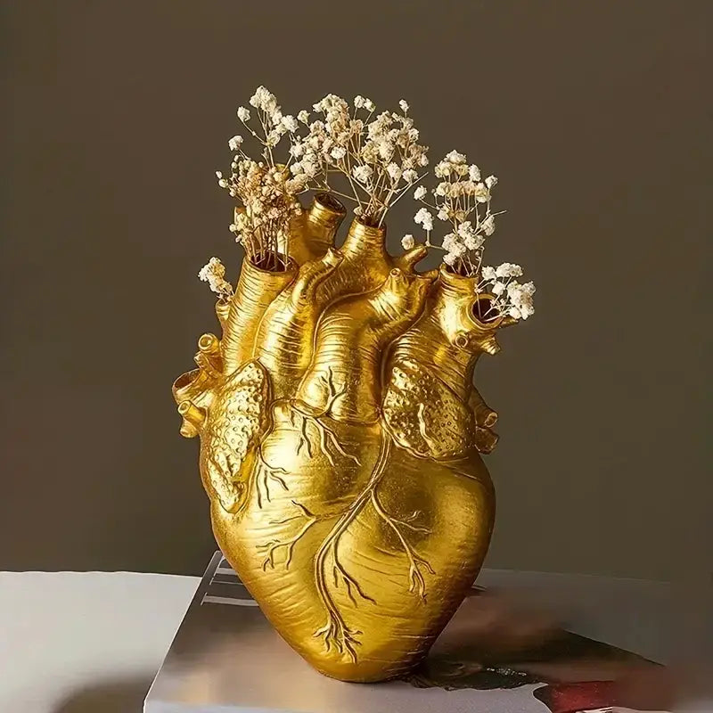 Golden heart shape resin vase with detailed vein textures holding dried white baby’s breath flowers by decorbites