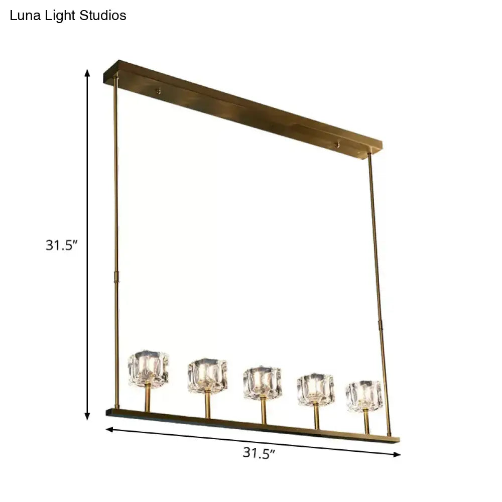 Gold-toned rectangular pendant light fixture with five faceted crystal glass shades and bulb base for dining room use