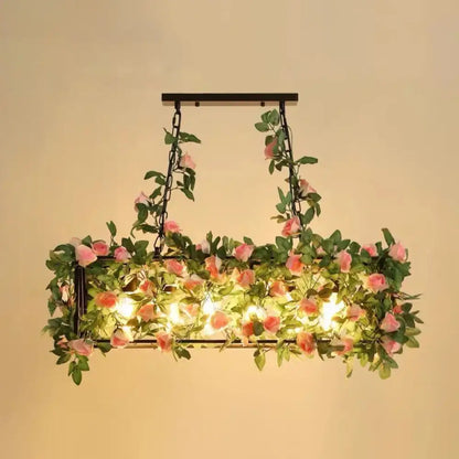 Rectangular black metal cage island pendant light with pink rose plant decoration for rustic restaurant lighting