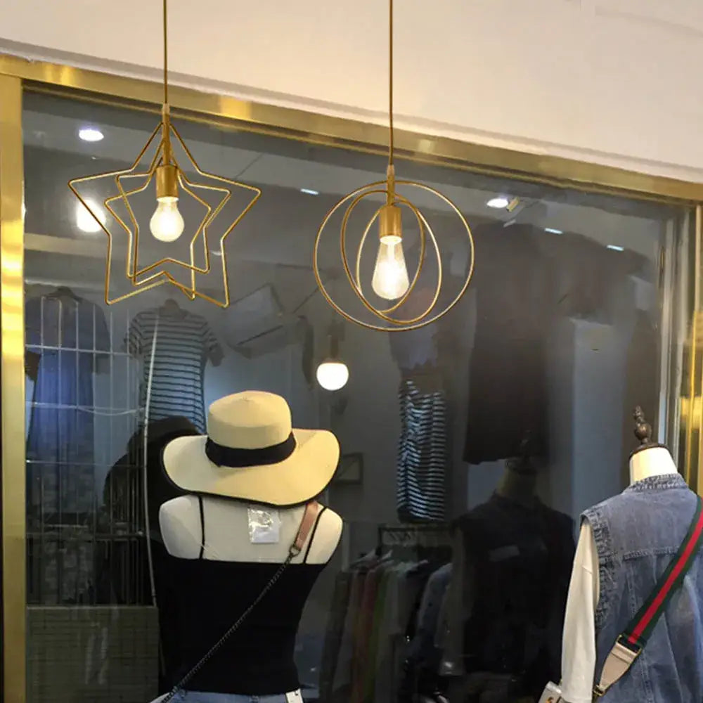 Gold star-shaped and circular pendant lights with exposed bulbs hang above storefront in decorbites industrial chandelier design