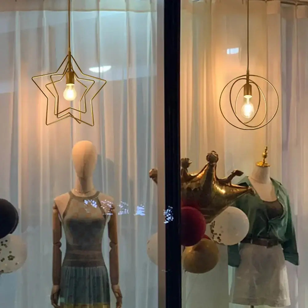 Gold star-shaped pendant light with a visible bulb inside from decorbites industrial chandelier in black circular ring design