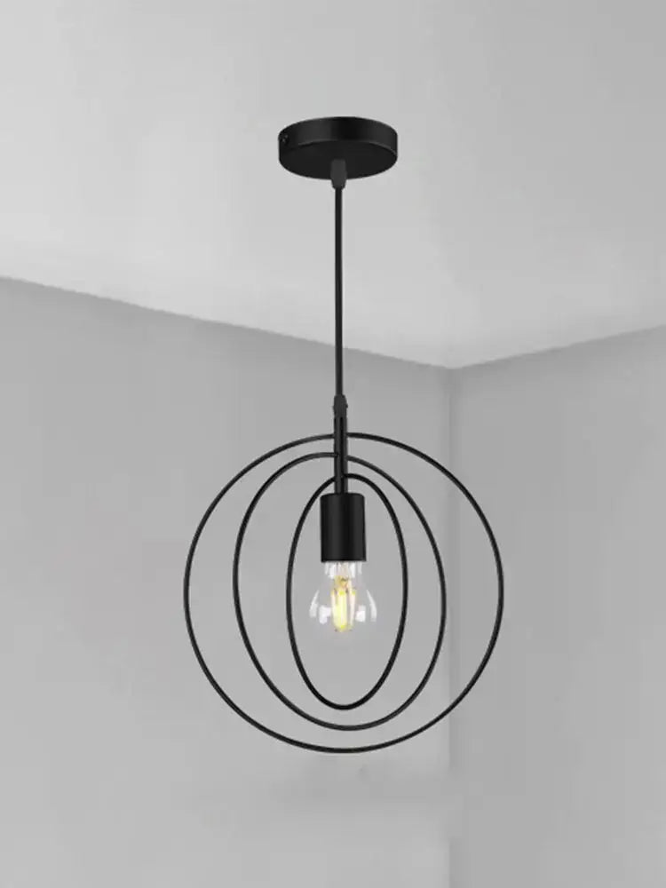 Black metal pendant light with concentric circular rings and filament bulb in decorbites industrial chandelier design